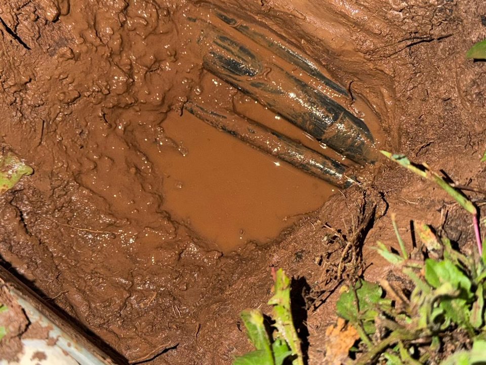 Iskop uz bazen u Krmedu: crna alkaten cijev od 1 cola u crvenici, s vodom koja se skupila u jami nakon puknuća, glavni vod vode do strojarnice bazena