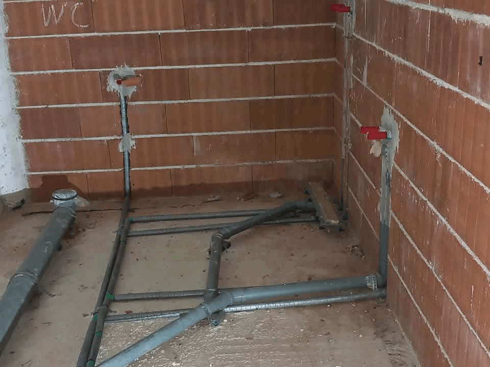 Odvodne cijevi za WC i umivaonik složene po podu, sa zatvornim ventilima u zidu