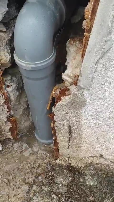 Stara izvedba pada odvodne cijevi Ø110 u niši fasade u Puli, s koljenom od 90° na vrhu, na kojem se stvarao čep